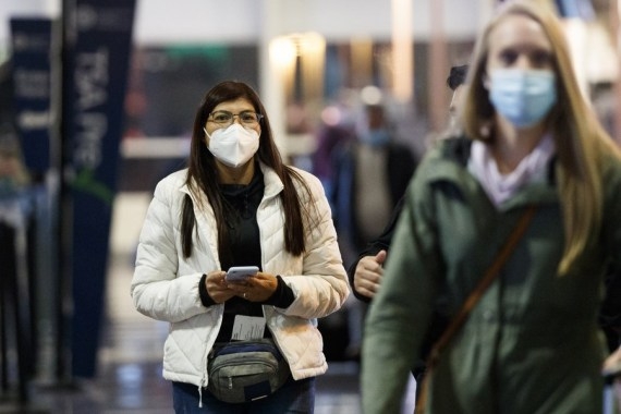 People wearing face masks are seen at Ronald Reagan Washington National Airport in Arlington, Virginia, the United States, on Dec. 23, 2020. (Photo by Ting Shen/Xinhua/ians)
