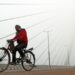 New Delhi: A man paddles the cycle as he passes through Signature bridge on a cold and foggy morning in New Delhi on Tuesday, December 27, 2022. (Photo: IANS/Wasim Sarvar)