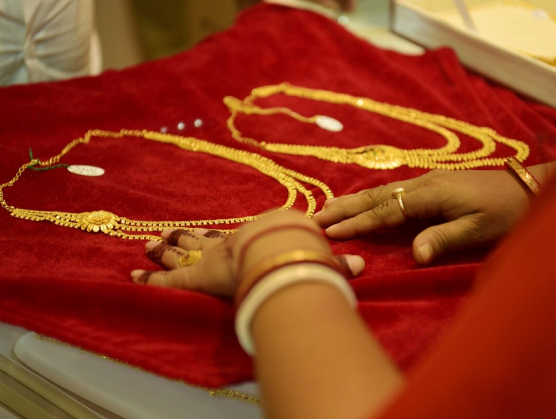 Agartala: A woman takes a look at a gold jewellery to buy ahead of Akshaya Tritiya festival, at a showroom in Agartala on Wednesday, Apr. 27, 2022.  (IANS/Abhisek Saha)