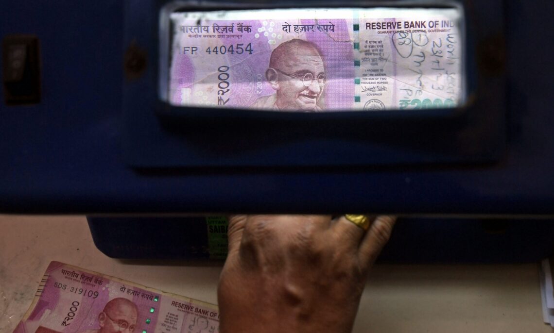 Mumbai : A staff member of Punjab National Bank checks for the duplicate and damaged Rs 2,000 currency notes  under an ultraviolet scanning machine, in Mumbai, on Thursday, May 25, 2023. The Reserve Bank of India has announced for withdrawal of Rs 2,000 currency notes from circulation, and existing notes in circulation can either be deposited in bank accounts or exchanged by September 30. (Photo: IANS)