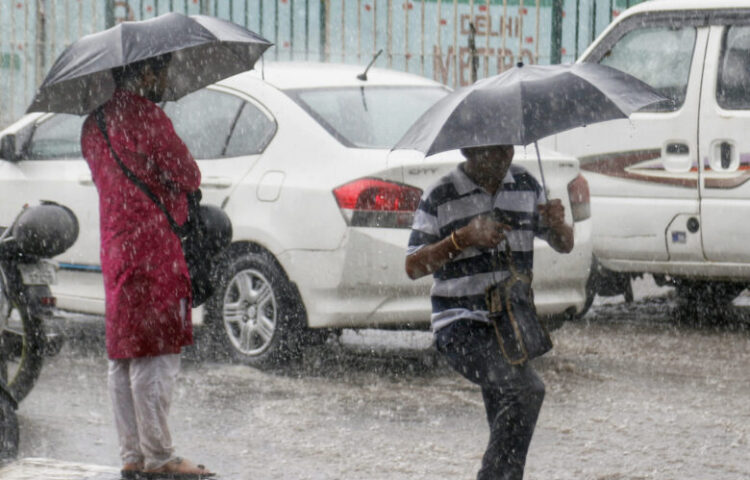 New Delhi: People use umbrella to cover themselves during heavy monsoon rains, in New Delhi on Wednesday July 12, 2023. (Photo: IANS/Wasim sarvar)