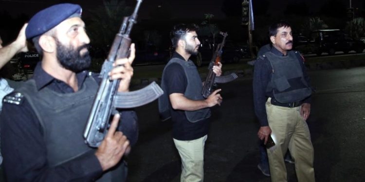 Police officers are seen near the site of an attack in Karachi, Pakistan, on Feb. 17, 2023. At least three attackers were killed and 10 people wounded on Friday night when a group of terrorists opened fire at a police building in Karachi, police and hospital officials said. (Str/Xinhua)