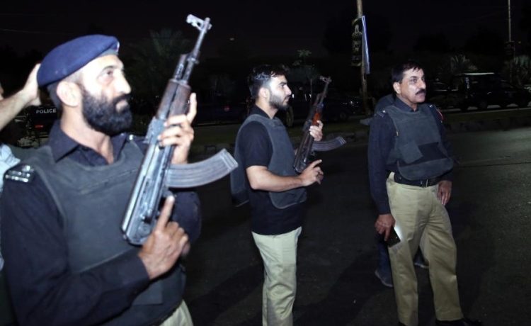 Police officers are seen near the site of an attack in Karachi, Pakistan, on Feb. 17, 2023. At least three attackers were killed and 10 people wounded on Friday night when a group of terrorists opened fire at a police building in Karachi, police and hospital officials said. (Str/Xinhua)