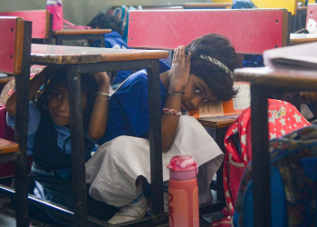 New Delhi: School students take shelter under the benches during a civil defence mock drill as a part of the nationwide mock drill at DTEA School, Lodhi Estate, in New Delhi, Wednesday, May 07, 2025. The Ministry of Home Affairs has instructed several states to conduct civil defence mock drills on May 7. (Photo: IANS)