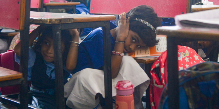 New Delhi: School students take shelter under the benches during a civil defence mock drill as a part of the nationwide mock drill at DTEA School, Lodhi Estate, in New Delhi, Wednesday, May 07, 2025. The Ministry of Home Affairs has instructed several states to conduct civil defence mock drills on May 7. (Photo: IANS)