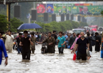 (250819) -- KARACHI, Aug. 19, 2025 (Xinhua) -- People wade through a flooded street after heavy monsoon rain in Karachi, Pakistan, on Aug. 19, 2025. (Str/Xinhua)