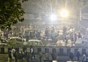 New Delhi: Police personnel stand near the charred remains of vehicles at the site of a car blast near Gate No.?1 of the Red Fort Metro Station, in New Delhi, Monday, November 10, 2025. (IANS/Wasim Sarvar)