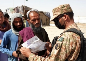 A Pakistani soldier checks documents of people before letting them cross into Pakistan at a border crossing point between Pakistan and Afghanistan, in southwest Pakistan's Chaman, on Aug. 27, 2021. (Str/Xinhua/IANS)