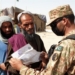 A Pakistani soldier checks documents of people before letting them cross into Pakistan at a border crossing point between Pakistan and Afghanistan, in southwest Pakistan's Chaman, on Aug. 27, 2021. (Str/Xinhua/IANS)
