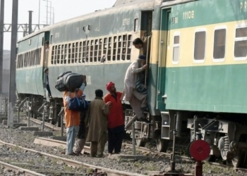 Passengers get on a train at a railway station ahead of the Islamic Eid al-Fitr festival in Lahore, Pakistan, April 30, 2022. (Photo by Sajjad/Xinhua/IANS)