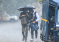 Noida: Commuters walk along a road holding an umbrella during sudden rainfall in the cold season, in Noida, Uttar Pradesh on Tuesday, January 27, 2026. (Photo: IANS)