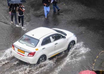 Mumbai: Commuters wearing raincoats ride a scooter amid monsoon rain in Mumbai on Friday, July 3, 2026. (Photo: IANS)